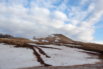 Bashkir hills in early spring with remnants of snow and dry grass.