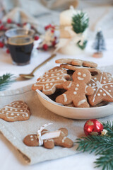 Variety of Christmas cookies decorated with icing frosted in a white bowl with espresso coffee in background and holidays decoration atmosphere