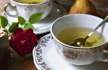 Close-up of some herbal teas next to a rose and some muffins