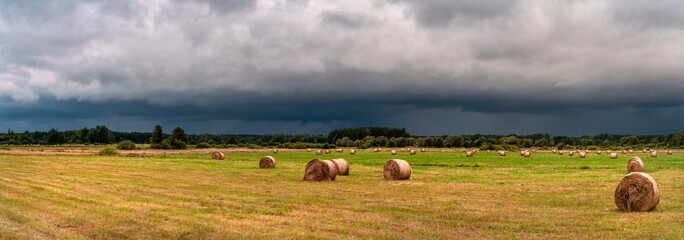 Dramatic view of a shelf cloud over a field, horizontal cloud formation, panorama view.
