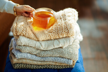 Closeup on modern woman with sweaters and tea