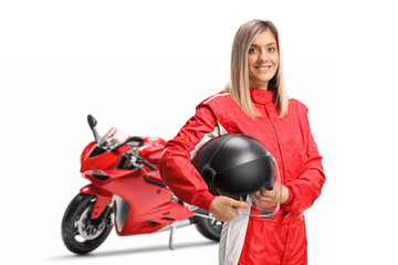 Fototapeta na wymiar Smiling female motorbike racer in a red suit holding a helmet