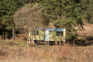 Long ago abandoned trailer green yellow warm sunny day autumn vibrant colors near ranch in bulgaria