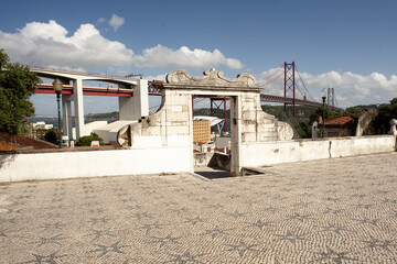 Fototapeta na wymiar 25 de Abril Bridge and church square in Lisbon