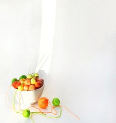 White basket with green and orange knitting yarn.