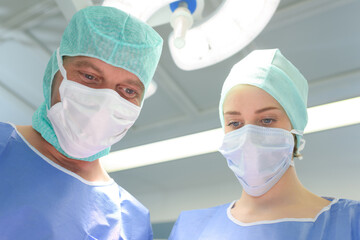 male and female surgeons in theater wearing facial masks