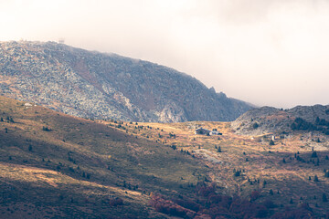 Autumn landscape in the mountains cloudy day sunrays wooden cottage on a ridge warm beautiful nature