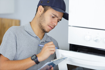 technician repairing oven in kitchen