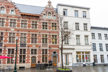 Fototapeta premium Traditional and modern buildings along a cobbled pedestrian street on a rainy winter day. Brussels, Belgium.