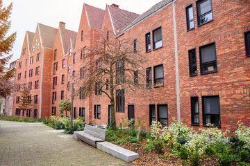 Fototapeta na wymiar Row of modern brick residential buildings along a a pedestrian pathway in a housing development in winter