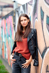 beautiful long-haired brunette against a background of street graffiti