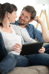 cheerful couple using digital tablet at home