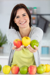 smiling young woman showing apples