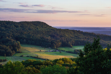Fototapeta na wymiar Romantische fränkische Sommerlandschaft im Abendrot in Bayern in Oberfranken bei Sonnenuntergang in den Hügeln
