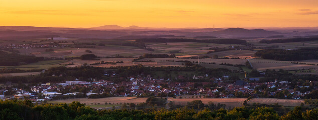 Fototapeta premium Romantische fränkische Sommerlandschaft im Abendrot in Bayern in Oberfranken bei Sonnenuntergang in den Hügeln