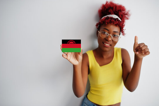 African woman with afro hair, wear yellow singlet and eyeglasses, hold Malawil flag isolated on white background, show thumb up.