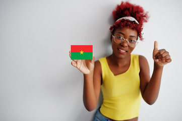 African woman with afro hair, wear yellow singlet and eyeglasses, hold Burkina Faso flag isolated on white background, show thumb up.