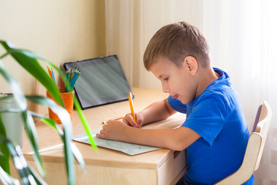 Cute child drawing picure at home. Child using gadgets for study. Education and distance learning concept