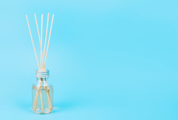 home fragrance in a glass diffuser with wooden sticks on a blue background