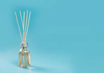 home fragrance in a glass diffuser with wooden sticks on a blue background