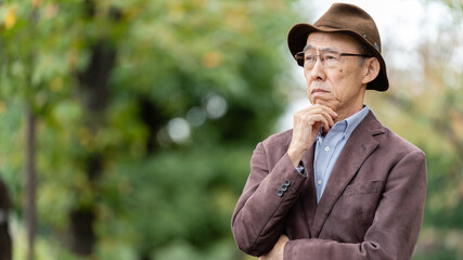 公園で考え事をするシニア男性