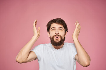 man in white t-shirt gesturing with his hands emotions fun pink background