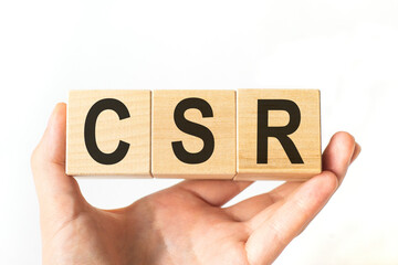 Word CSR. Wooden small cubes with letters isolated on white background with copy space available