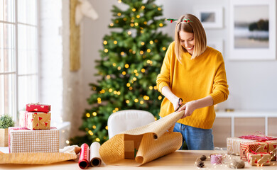 happy   woman gets ready for christmas and wrapping a gift.