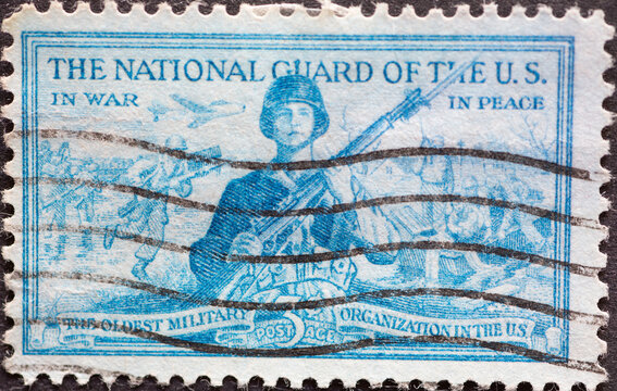 
a postage stamp printed in the US showing a National Guardsman ready for action. The two background images picture a guardsman in a war scene and another protecting life and property.