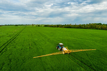 Farm machine sprayer chemicals wheat green field. Modern technology of agriculture aerial view from drone