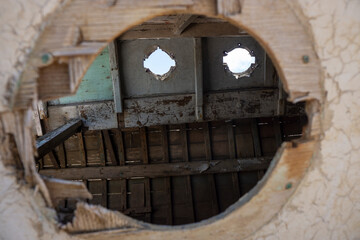 Interior of an old derelict boat through broken porthole.