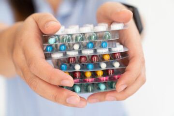 Hand holding antibiotics capsule pills in blister packaging for treatment infection patient in...
