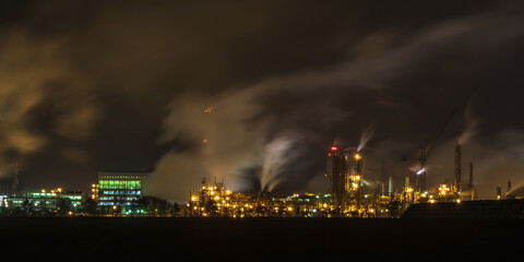 night industrial landscape environmental pollution waste of thermal power plant. Big pipes of chemical industry enterprise plant