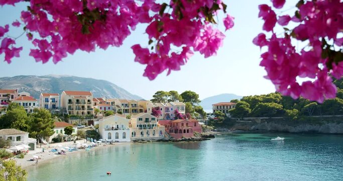 Beautiful small Assos village on Kefalonia Island, Greece. Flower blossom in foreground. Top summer vacation tourism destination