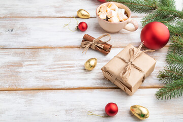 Christmas or New Year composition. Decorations, box, balls, fir and spruce branches, cup of coffee, on a white wooden background. Side view, copy space.