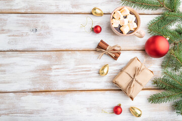 Christmas or New Year composition. Decorations, box, balls, fir and spruce branches, cup of coffee, on a white wooden background. Top view, copy space.