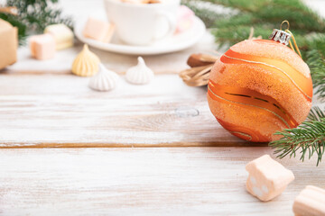 Christmas or New Year composition. Decorations, box, balls, fir and spruce branches, cup of coffee, on a white wooden background. Side view, copy space, selective focus.
