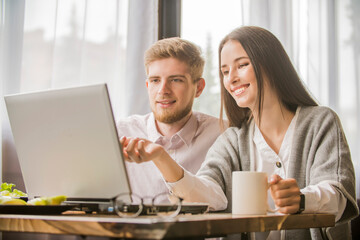 
girl and a guy communicate on laptop together,  remote communication on the Internet observing a social distance