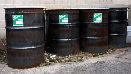 Row of sealed metal barrels labeled NON HAZARDOUS WASTE.