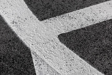 white lines marking basketball field on a bituminous surface, close up sports area border line white paint on asphalt texture, nobody.