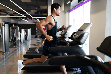 Focused young man on a treadmill in the gym