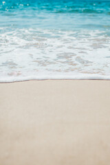 Fototapeta na wymiar Soft blue ocean wave on sandy beach. Background.