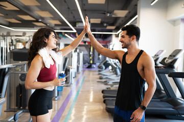Young woman and man laughing at the gym