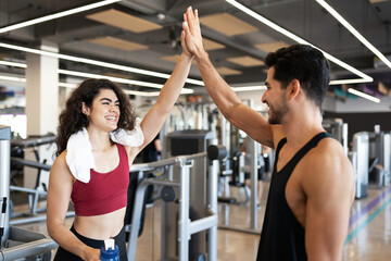 Fototapeta na wymiar Couple doing a high five at the gym