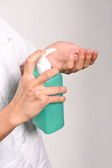 Enfermera se echa alcohol desinfectante en las manos