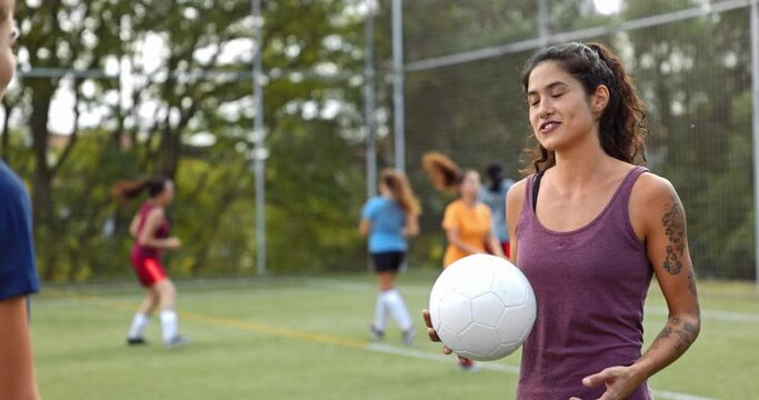 Female soccer player talking with teammate during practise