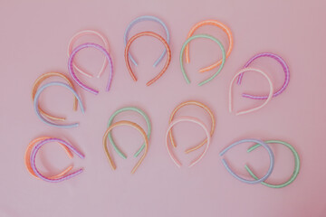 Many colorful tiaras. Studio photo with pink background.
