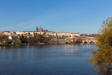 Fototapeta na wymiar Autumn colorful Prague Lesser Town with gothic Castle and Charles Bridge above River Vltava in the sunny Day, Czech Republic