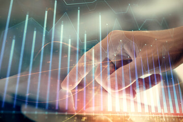 Multi exposure of man's hands holding and using a phone and financial chart drawing. Market analysis concept.