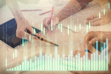 Double exposure of forex graph drawing and man and woman working together holding and using a mobile device. Trade concept.